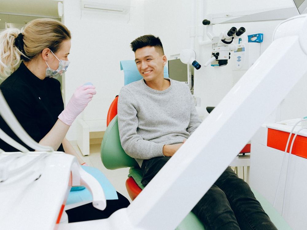 Dentist talking with a smiling patient before a checkup